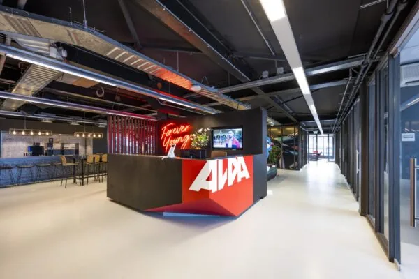 Moderne receptiebalie van AWA aan de Anthony Fokkerweg met neontekst "Forever Young" en een industrieel interieur.